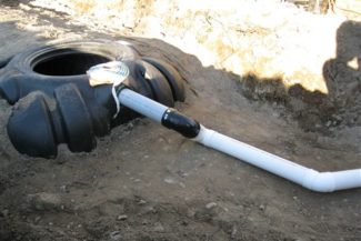 plastic septic holding tank half uncovered in the ground