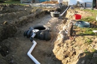 plastic septic holding tanks being installed in back of house