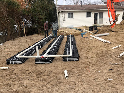 Eljen septic install in back of house with two workers on site